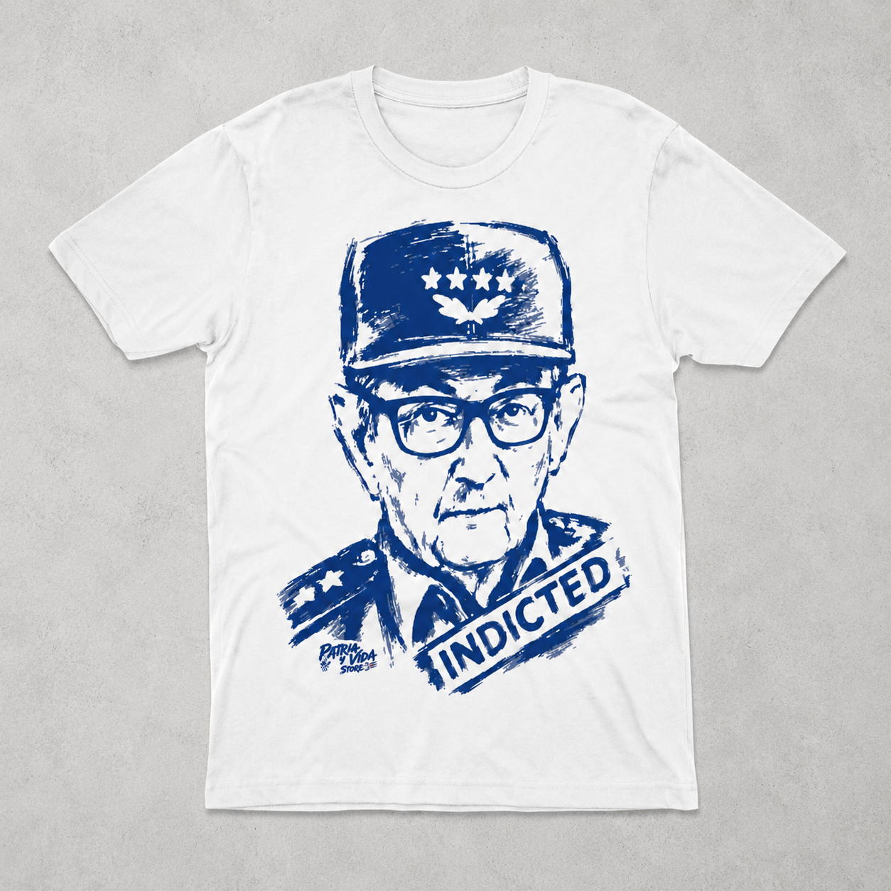 White t-shirt with blue graphic of a Raul Castro in military uniform and 'INDICTED' text on a gray background